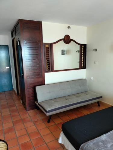 a living room with a couch and a mirror at Appartements vue mer - Résidence de la baie - Tartane in La Trinité