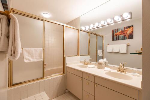 uma casa de banho com 2 lavatórios e um espelho grande em Scorpio Condominiums by Vail Realty em Vail
