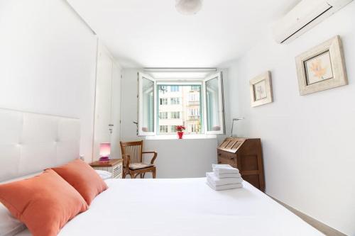 een witte slaapkamer met een bed en een raam bij Felix Saenz Apartments! in Málaga