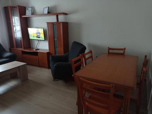 a living room with a table and chairs and a television at Vivienda Turística Bufer Cazorla in Cazorla