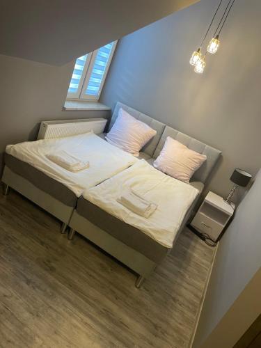 a small bedroom with a bed with white sheets and pillows at Zakątek przy lesie 