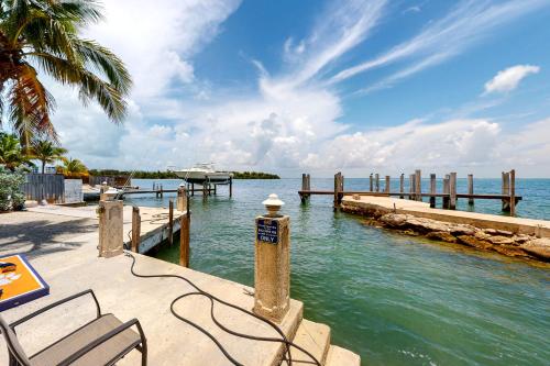 a dock with a bench and a boat in the water at Cool Water Retreat in Marathon