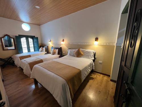a bedroom with two beds in a room at Hotel La Gran Casona in Tunja