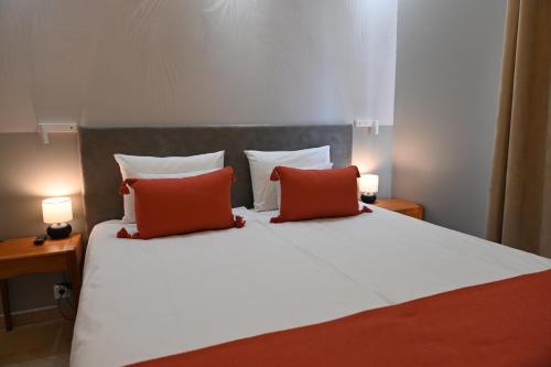 a bedroom with a bed with two red pillows at H49 Jacuzzi Penthouse-Adults only in Sovata