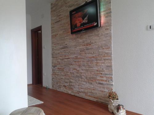 telewizor na murze z telewizorem w obiekcie Apartmani i sobe Milojević w mieście Trebinje