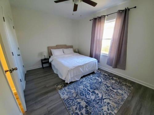 a bedroom with a bed and a window and a rug at Lakewoodlyon Park Renovated Cottage Near Duke 26a in Durham