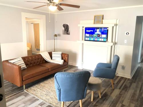 a living room with a couch and two chairs and a tv at Renovated 3 bedroom close to downtown! in Durham