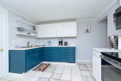 a kitchen with blue cabinets and white appliances at Renovated 3 bedroom close to downtown! in Durham