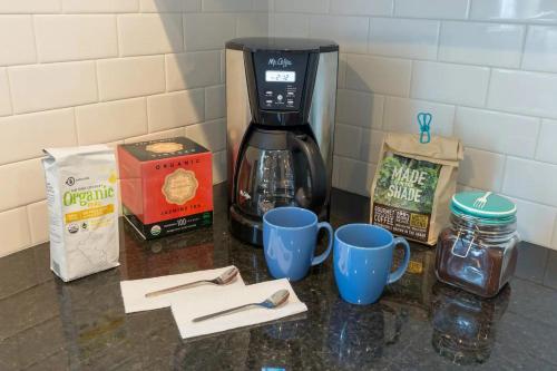 a counter with cups and a coffee maker on it at Recently Renovated Chic Durham Farmhouse in Durham