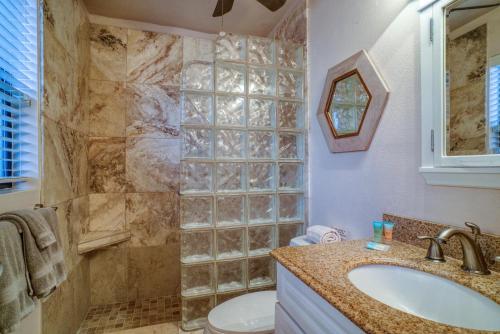 a bathroom with a sink and a toilet and a shower at Suite Maui Paradise Condo in Wailuku