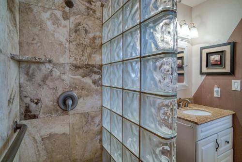 La salle de bains est pourvue d'une douche avec un mur en verre. dans l'établissement Suite Maui Paradise Condo, à Wailuku