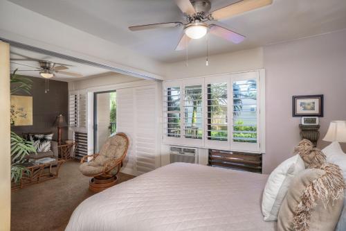 - une chambre avec un lit et un ventilateur de plafond dans l'établissement Suite Maui Paradise Condo, à Wailuku