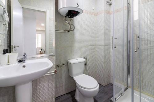 a bathroom with a toilet and a sink and a shower at Churruca Apartments! in Málaga