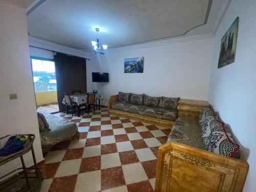 a living room with a couch and a checkered floor at Complexe Jardins andalouse in Tangier