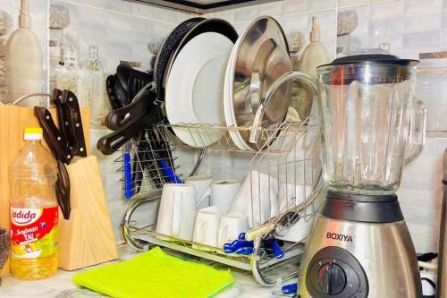 eine Küchentheke mit Mixer, Tellern und Küchenutensilien in der Unterkunft appartement meublé avec spa jacuzzi in M'bour