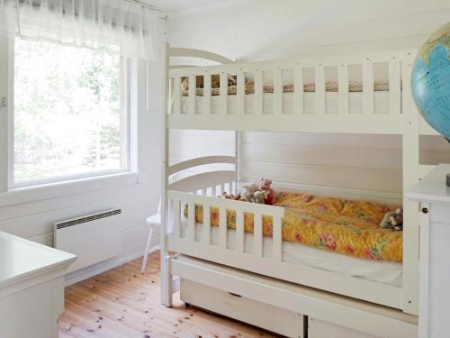 a childs bedroom with a bunk bed and a window at Holiday home YXLAN in Yxlö