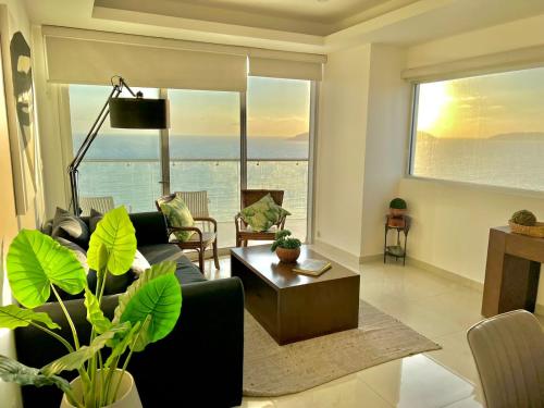 a living room with a couch and a table at Sunset View Malecón 1401 Vista panoramica al mar in Mazatlán