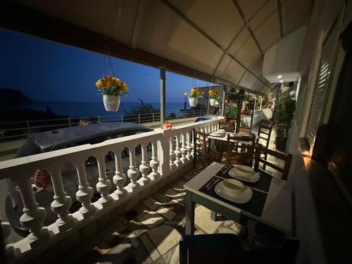 a balcony with a view of the ocean at night at Lazaris kwstas Rooms in Himare