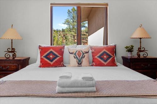 um quarto com uma cama com almofadas vermelhas e uma janela em Oak Ridge at Palisades em Sedona