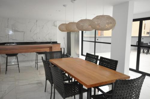 uma sala de jantar com uma mesa de madeira e cadeiras em Studio no centro em Poços de Caldas