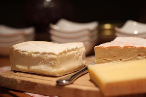 two blocks of cheese on a cutting board with a fork at Gasthaus Hotel zum Kreuz in Stetten am Kalten Markt