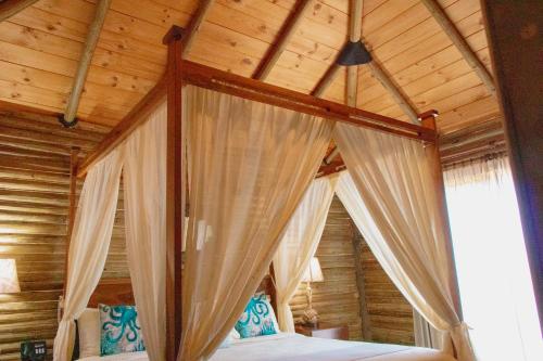 Cama con dosel en una habitación con techo de madera en Gran Altata All Inclusive en Altata