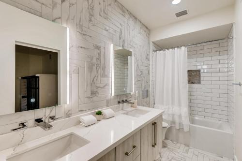 uma casa de banho branca com 2 lavatórios e um espelho em Parkway Paradise em Scottsdale