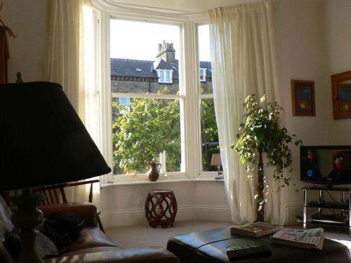 a living room with a large window and a couch at 16 Franklin Bijou Boutique in Harrogate