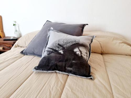 Una almohada con una foto de un hombre en una cama en Departamento WOOD en Caleta Olivia