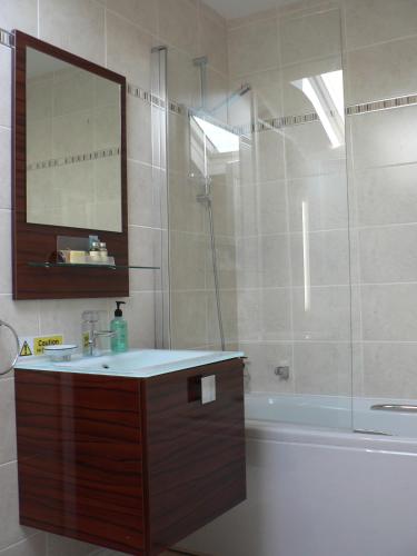 a bathroom with a sink and a tub and a mirror at 16 Franklin Bijou Boutique in Harrogate