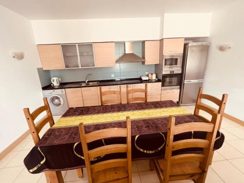 a kitchen with a table and chairs and a refrigerator at Apartamento T2 equipado Vila Verde in Santa Maria