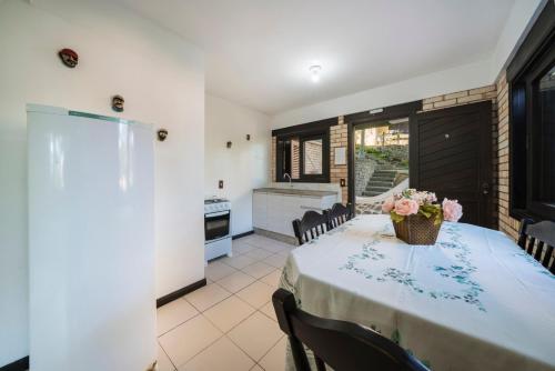 a dining room with a table with flowers on it at Pousada Albacora in Bombinhas