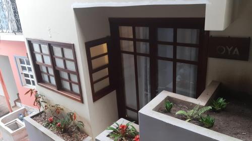 Casa Oyá في مورو دي ساو باولو: إطلالة على مبنى فيه نباتات الفخار أمام باب