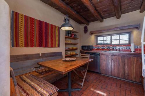 a kitchen with a wooden table and a counter at Canyon Getaway- Courtyard, Canyon Rd & Plaza, 1BR in Santa Fe