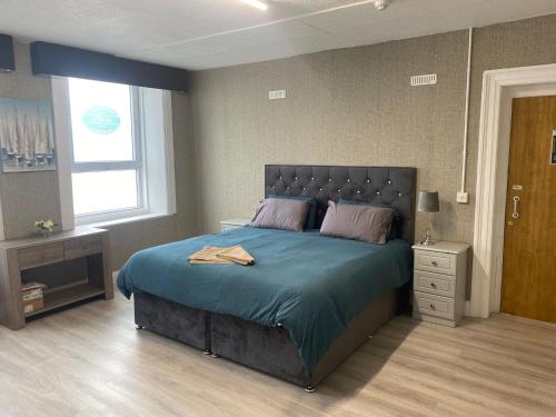 1 dormitorio con 1 cama grande con manta azul en Waterford Hostels Ltd, en Waterford