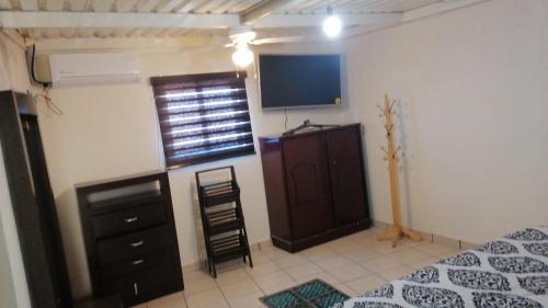 Schlafzimmer mit einem Bett, einem TV und einer Kommode in der Unterkunft Casa Lopez Camarena Arandas Jalisco in Arandas