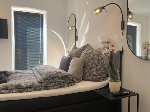 Schlafzimmer mit einem Bett mit einem Spiegel und Kissen in der Unterkunft stilvolles, neues Apartment mit Balkon in Bamberg in Bamberg