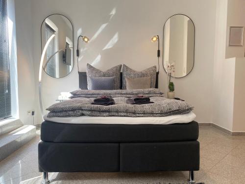 ein Schlafzimmer mit einem großen Bett mit zwei Spiegeln in der Unterkunft stilvolles, neues Apartment mit Balkon in Bamberg in Bamberg