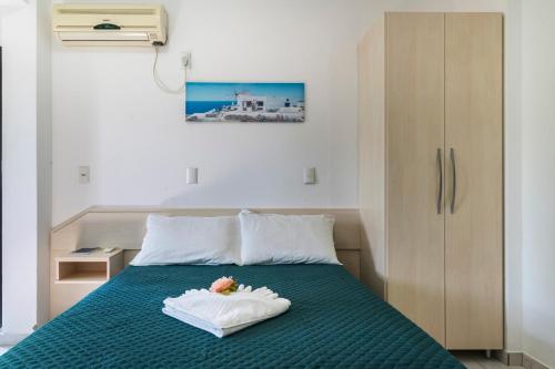 a small bedroom with a bed with a green bedspread at Pousada Albacora in Bombinhas
