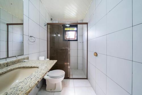 a bathroom with a tub and a toilet and a sink at Pousada Albacora in Bombinhas
