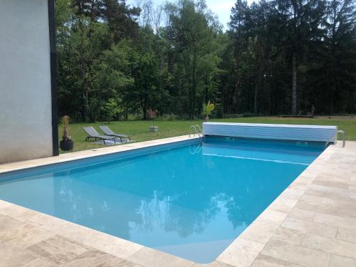 - une piscine dans une cour avec 2 chaises dans l'établissement chambre à la campagne, à Chaumont-sur-Tharonne