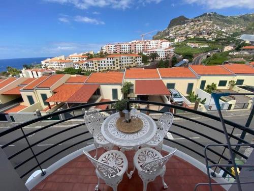 a table and chairs on a balcony with a view at Residência Azevedo in Câmara de Lobos