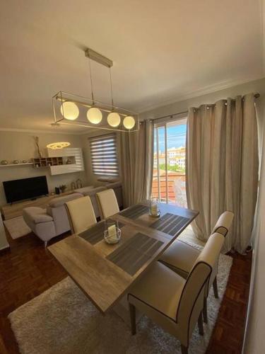 a living room with a dining room table and chairs at Residência Azevedo in Câmara de Lobos