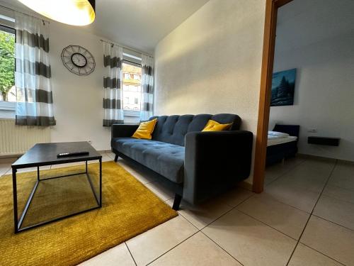 un soggiorno con un divano blu e un tavolo di Giulia Ferienwohnung - Zentral a Tuttlingen