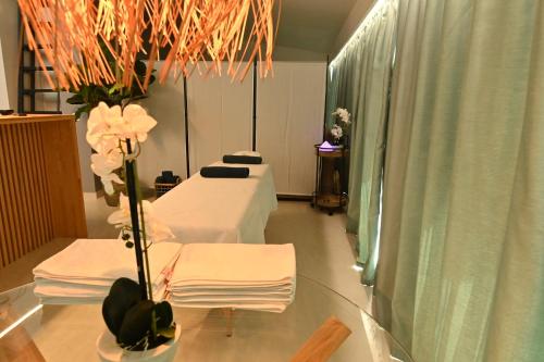 ein Krankenhauszimmer mit 2 Betten und einem Tisch mit Blumen in der Unterkunft H49 Jacuzzi Penthouse-Adults only in Sovata