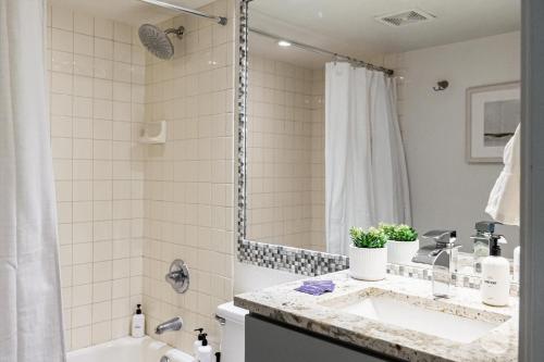 a white bathroom with a sink and a shower at 1 Bedroom Apt - Gym - DTC Boston Commons in Greenwood Village