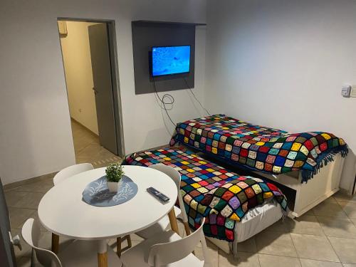 a small room with a table and a bed and a table and chairs at Departamento 3 centro - Cardiológico con cochera in Corrientes