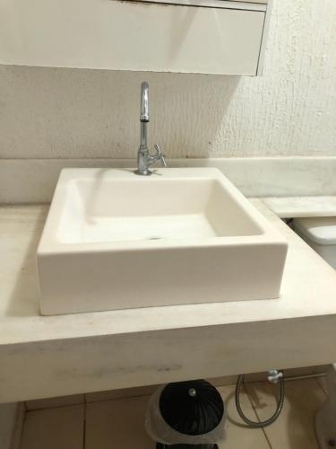 a white sink in a bathroom with a counter at Residencial Parque da Liberdade IV in Sao Jose do Rio Preto