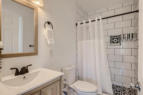 a bathroom with a sink and a toilet and a mirror at The Cosmopolitan Cottage in Phoenix