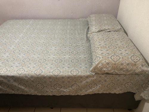 an unmade bed with a blanket on top of it at Residencial Parque da Liberdade IV in Sao Jose do Rio Preto
